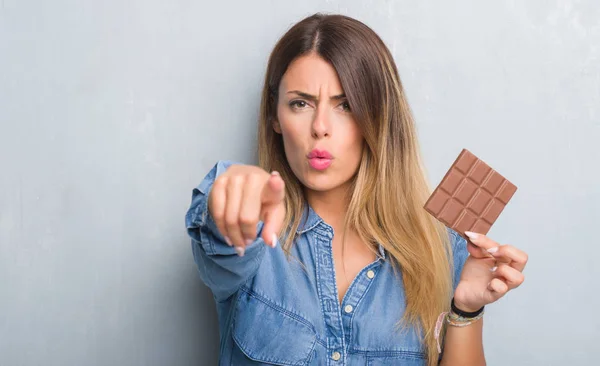 Νεαρή Ενήλικη Γυναίκα Πάνω Από Τοίχο Γκρι Grunge Τρώει Σοκολάτα — Φωτογραφία Αρχείου