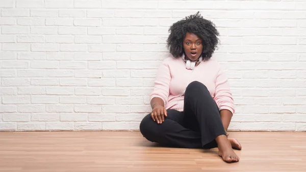 Young African American Woman Sitting Floor Wearing Headphones Afraid Shocked — Stock Photo, Image