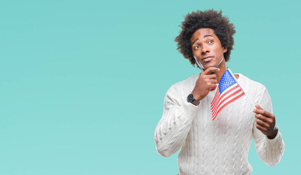 Afro american man flag of United States of America over isolated background serious face thinking about question, very confused idea