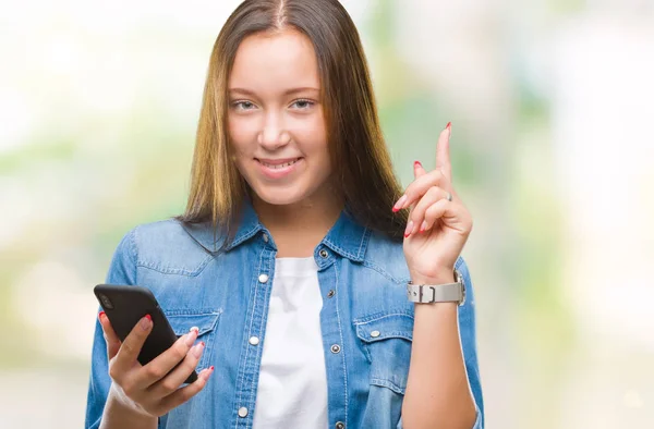 年轻美丽的高加索妇女发短信发送消息使用智能手机在孤立的背景惊讶的想法或问题指向手指与幸福的脸 — 图库照片