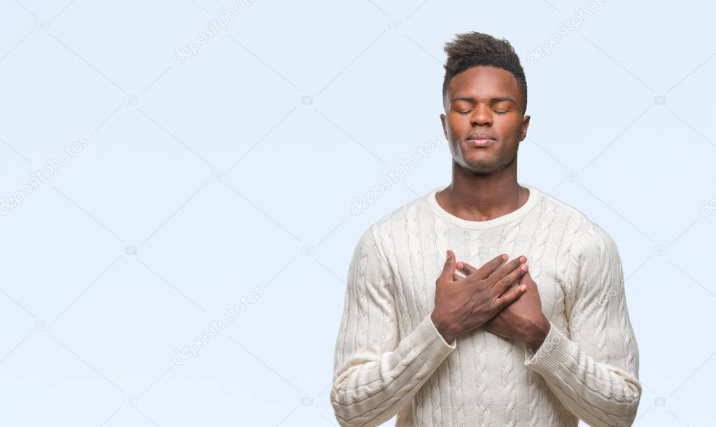 Young african american man over isolated background smiling with hands on chest with closed eyes and grateful gesture on face. Health concept.