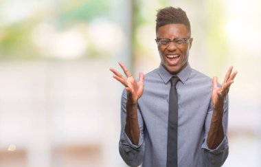 Genç Afro-Amerikalı iş adamı deli ve silah ile başarı için deli kutluyor izole arka plan üzerinde kaldırdı ve heyecanlı çığlık gözler kapalı. Kazanan kavramı