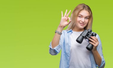 Parmak, mükemmel sembolü ile ok işareti yapıyor izole arka plan üzerinde dürbün tutan genç beyaz kadın