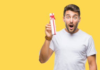 Sevgililer hediye izole arka şok sürpriz yüzü, korkuyor ve korku ifadesi ile heyecanlı olan korkmuş üzerinden veren aşık genç yakışıklı adam