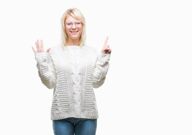 Numara altı ise kendinden emin ve mutlu gülümseyen genç güzel sarışın kadın giyiyor kış kazak ve gözlük gösterilen ve parmakları ile işaret izole arka plan üzerinde.