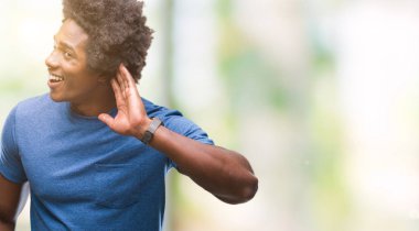 Bir işitme söylenti ya da dedikodu için dinleme kulak üzerinde el ile gülümseyen izole arka plan üzerinde Afro Amerikalı adam. Sağırlık kavramı.