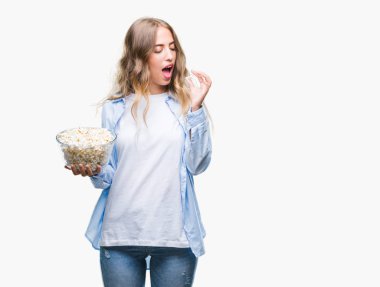 Acımak yüz ciddi düşünüyorum üstünde kendine güvenen bir ifade ile izole arka plan üzerinde patlamış mısır yemek güzel sarışın genç kadın