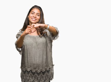 Genç güzel Arap kadın kalp simgesi ve elleriyle şekil gösterilen aşık gülümseyen izole arka plan yüzünden. Romantik kavramı.