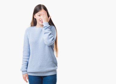 El yüz ve sürpriz duygu kendinden emin gülümseme ile tek gözüyle kapsayan izole arka plan üzerinde Genç Çinli kadın.