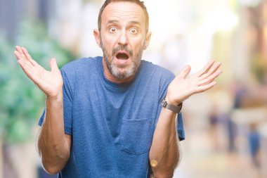 Orta yaş izole arka plan clueless ve şaşkın bir ifadeyle kollar ve eller kaldırdı üzerinde ağarmış komuta sizde. Şüphe kavramı.