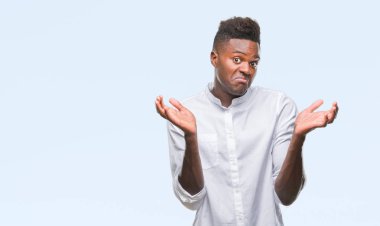 Afrikalı-Amerikalı genç izole arka plan clueless ve şaşkın bir ifadeyle kollar ve eller ortaya çıkar üzerinden. Şüphe kavramı.