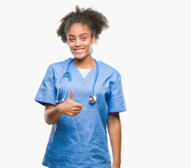 Genç afro Amerikalı doktor kadın hareketi el ile mutlu yaşasın yapıyor izole arka plan yüzünden. Kameraya bakarak başarı gösteren ile ifade onaylama.