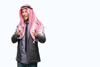 Genç yakışıklı Arap adam uzun saçlı keffiyeh fotoğraf makinesi ile mutlu ve komik yüz için parmakları işaret izole arka plan üzerinde giyiyor. İyi enerji ve vibes.