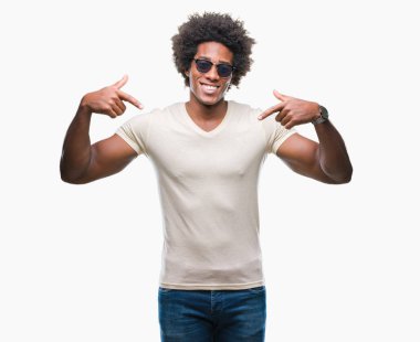 Yüzünde gülümseme ile kendinden emin görünüyorsun, kendini gururlu ve mutlu parmakları ile işaret izole arka plan üzerinde güneş gözlüğü takıyor Afro Amerikalı adam.