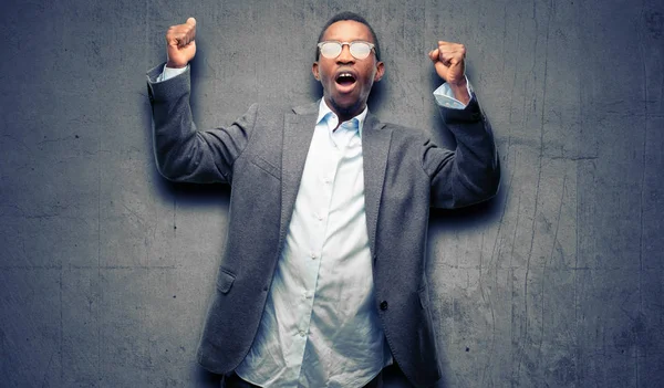 African black man wearing jacket happy and excited celebrating victory expressing big success, power, energy and positive emotions. Celebrates new job joyful