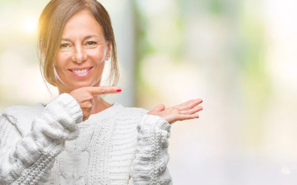 中年资深西班牙裔妇女穿着冬季毛衣在孤立的背景下 用手和手指指指点点 对着镜头微笑 — 图库照片
