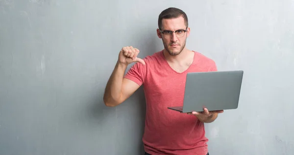 Joven Caucásico Hombre Sobre Gris Grunge Pared Utilizando Ordenador Portátil — Foto de Stock