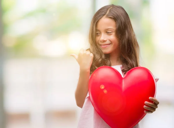 Μελαχρινή Κορίτσι Ισπανόφωνος Κρατώντας Κόκκινη Καρδιά Κατάδειξης Και Δείχνοντας Αντίχειρα — Φωτογραφία Αρχείου
