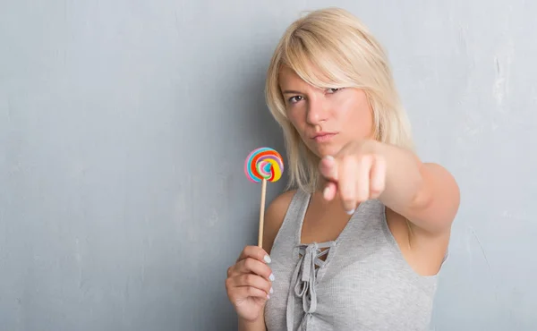 Caucasian Adult Woman Grey Grunge Wall Eating Candy Lollipop Pointing — Stock Photo, Image