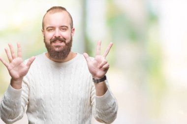 Genç beyaz hipster adam giyen kış kazak üzerinde gösterilen arka plan izole ve parmakları ile işaret gülümseyen ise kendinden emin ve mutlu 8 numaralı.