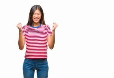 Genç Asyalı kadın kutluyor izole arka plan üzerinde şaşırttı ve başarı için kaldırdı kollarını açarak hayret ve gözleri açık. Kazanan kavramı.