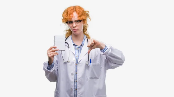 Jovem Mulher Médica Ruiva Segurando Notebook Branco Com Rosto Irritado — Fotografia de Stock