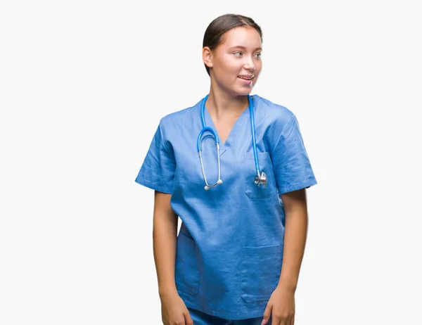 上医療制服を着て若い白人医師女性隔離背景が笑顔で側に自然な表現の顔に離れています 自信を持って笑ってください — ストック写真