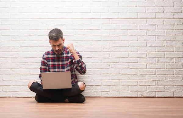 Hombre Adulto Joven Sobre Pared Ladrillo Usando Portátil Molesto Frustrado — Foto de Stock