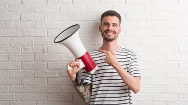 Megafon çok mutlu el ve parmak ile işaret tutan genç yetişkin adam