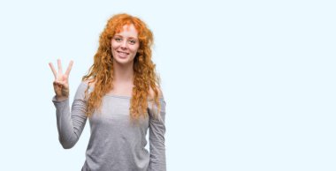 Gösterilen ve parmakları ile işaret genç Kızıl saçlı kadın kendinden emin ve mutlu gülümseyerek iken üçüncü.