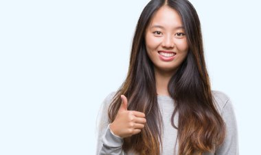 Genç Asyalı kadın hareketi el ile mutlu yaşasın yapıyor izole arka plan üzerinde. Kameraya bakarak başarı gösteren ile ifade onaylama.