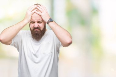 Çünkü çaresiz ve stresli baş ağrısı acı izole arka plan üzerinde rahat t-shirt giyen genç beyaz hipster adam ağrı ve migren. Ellerini kafasına.