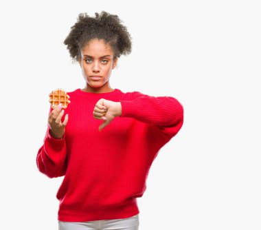 Genç güzel afro Amerikalı kadın kızgın yüzü, eksi işareti aşağı antipati başparmak ile gösterilen, ret kavramı ile izole arka plan üzerinde gözleme yemek