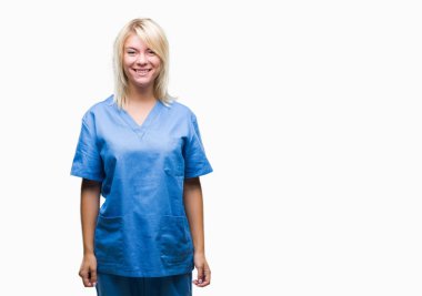 Genç güzel sarışın hemşire doktor kadın yüzünde mutlu ve güzel bir gülümseme ile izole arka plan yüzünden. Şanslı kişi.