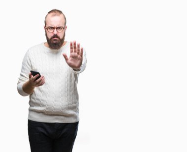 Genç beyaz hipster adam manifatura açık eliyle dur işareti ile ciddi ve kendine güvenen ifade, savunma jest yapıyor izole arka plan üzerinde Smartphone kullanarak ileti gönderme