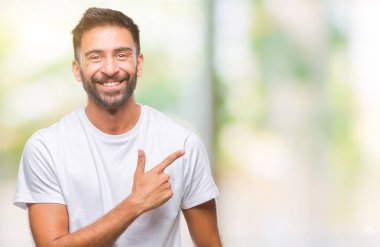 İzole arka neşeli bir gülümseme ile el ve parmak kadar kameraya bakarak yüzündeki mutlu ve doğal ifade ile yan ile işaret yüz yetişkin İspanyol adam.