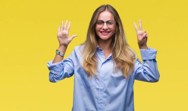 Genç güzel sarışın iş kadın gözlük gösterilen ve parmakları ile işaret izole arka plan üzerinde kendinden emin ve mutlu gülümseyerek süre yedi numara.