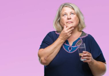 Kıdemli artı boyutu arka plan ciddi bir yüz hakkında soru, çok karışık bir fikir düşünce kafkas kadın üzerinde bardak su içme izole