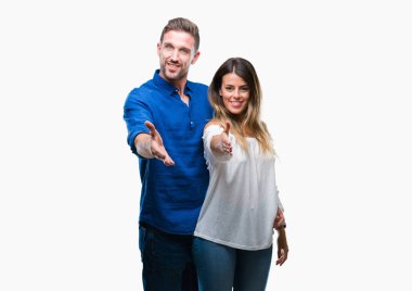 Tebrik ve konuksever dost sunan karşılıklı gülümseyen izole arka plan üzerinde aşık genç bir çift. Başarılı iş.