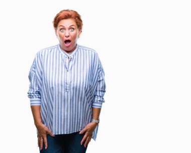 Atrractive üst düzey beyaz Kızıl saçlı kadın izole arka plan korkuyor ve sürpriz ifade, korku ve heyecan yüz ile şok yüzünden.