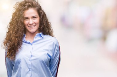 Yüzünde mutlu ve güzel bir gülümseme ile izole arka plan üzerinde güzel esmer kıvırcık saçlı Genç kız giyen elgant bak. Şanslı kişi.