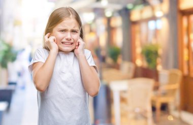 Yüksek sesle müzik gürültü rahatsız ifade parmaklarıyla kulaklarıyla kapsayan izole arka plan üzerinde genç güzel kız. Sağır kavramı.