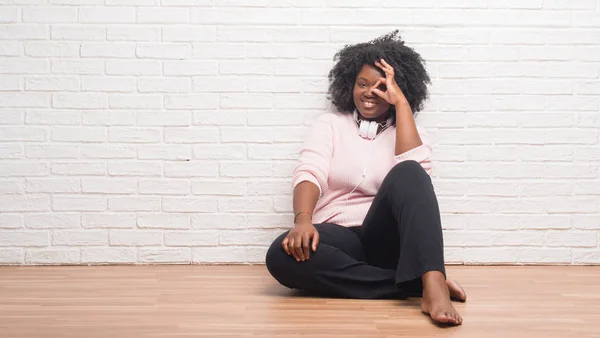 Young African American Woman Sitting Floor Wearing Headphones Doing Gesture — Stock Photo, Image