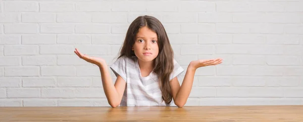 Jonge Latino Jongen Zittend Tafel Bij Huis Clueless Verward Expressie — Stockfoto