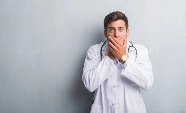 Guapo Joven Doctor Hombre Sobre Gris Grunge Pared Impactado Cubriendo — Foto de Stock