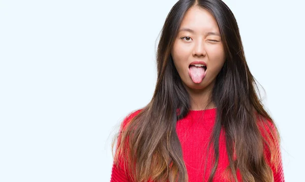 Stock image Young asian woman wearing winter sweater over isolated background sticking tongue out happy with funny expression. Emotion concept.