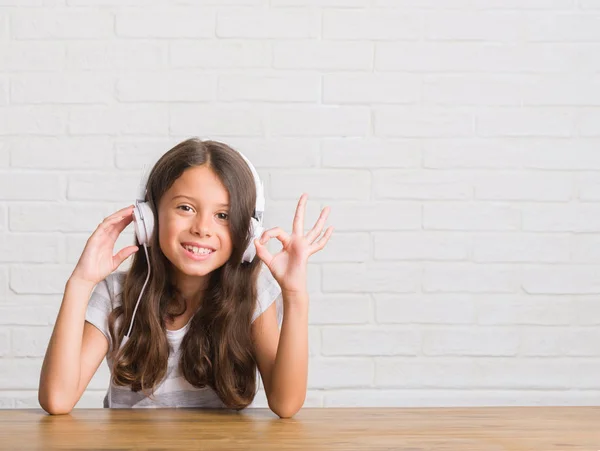 Giovane Bambino Ispanico Seduto Sul Tavolo Con Cuffie Facendo Segno — Foto Stock