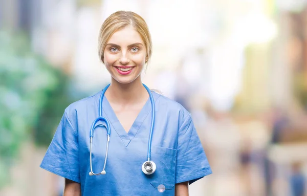 年轻美丽的金发医生外科护士妇女在孤立的背景与一个愉快和凉爽的笑容在脸上 幸运的人 — 图库照片
