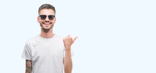 Young Tattooed Adult Man Wearing Sunglasses Pointing Showing Thumb Side — Stock Photo, Image