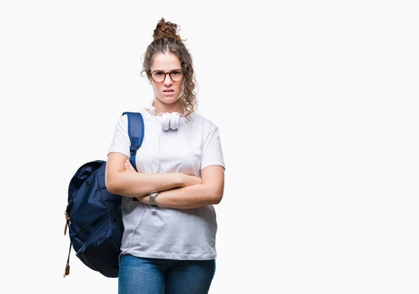 ブルネットの学生の若い女の子が懐疑的な孤立した背景と組んだ腕で顔の神経 不賛成式バックパックとヘッドフォンを着用します 否定的な人 — ストック写真